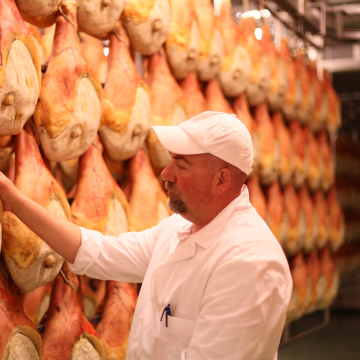 An artisan crafting Parma ham